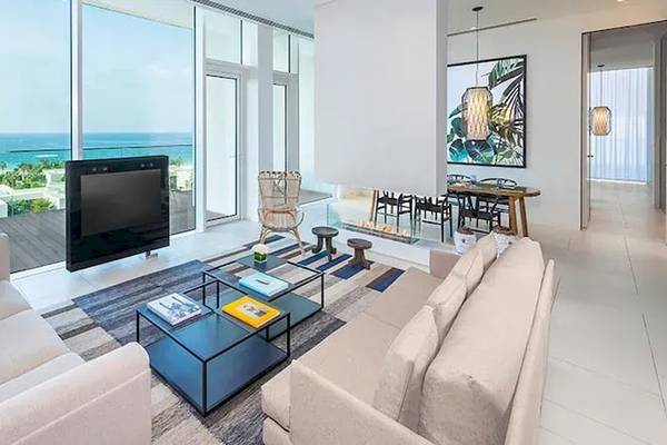 Wohnzimmer des Oberoi Beach Resorts in Al Zorah mit Meerblick, Flachbildfernseher, Sofas, Couchtisch und Esstisch.