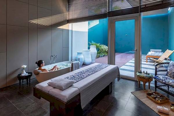 Innenansicht des Spa-Bereichs im Oberoi Beach Resort, Al Zorah, mit einer Frau im Whirlpool.