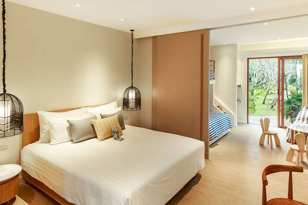 Schlafzimmer im Bandara Resort & Spa, Samui, mit einem großen Bett und einem Sofabereich.