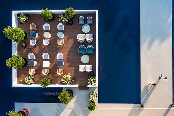 Luftaufnahme der Terrasse im Oberoi Beach Resort Al Zorah mit Tischen und Stühlen