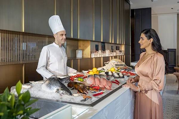 Koch präsentiert Fische im Oberoi Beach Resort.