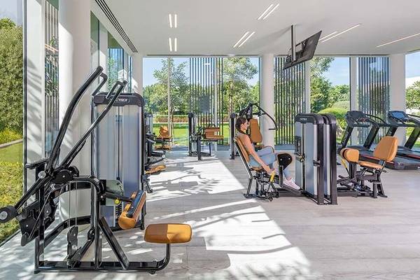 Fitness-Center im Oberoi Beach Resort Al Zorah mit modernen Geräten und einer Frau, die sich entspannt.