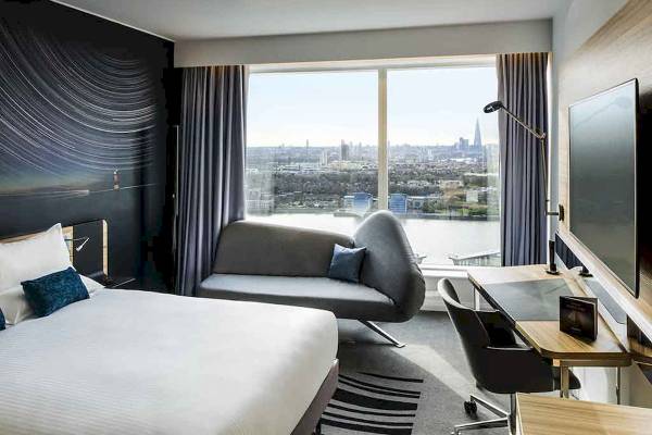 Innenansicht eines Zimmers im Novotel London Canary Wharf mit Blick auf die Stadt.