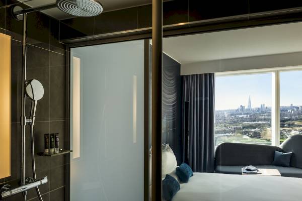 Ein Zimmer im Novotel London Canary Wharf mit Blick aus der Dusche auf die Stadt.