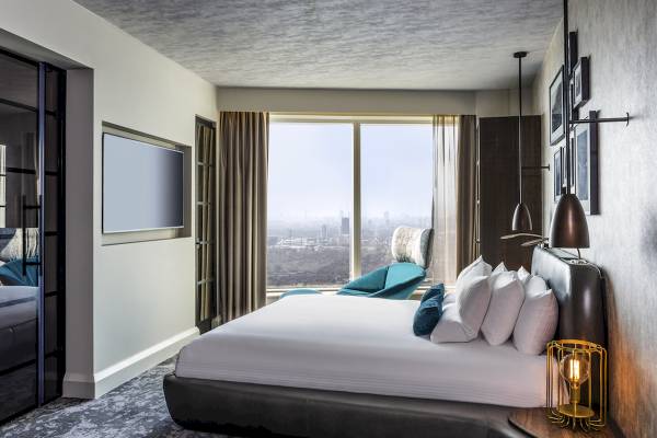 Innenansicht eines Hotelzimmers im Novotel London Canary Wharf mit Bett, Fernseher und Stadtblick.