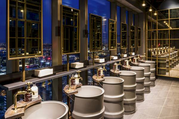 Badezimmer im Novotel London Canary Wharf mit Blick auf die Stadt bei Nacht.