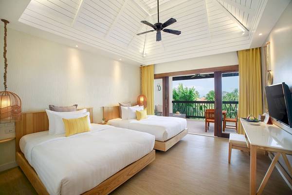 Innenansicht eines Doppelzimmers im Bandara Resort & Spa, Samui mit zwei Betten, einem Fernseher und einem Balkon.