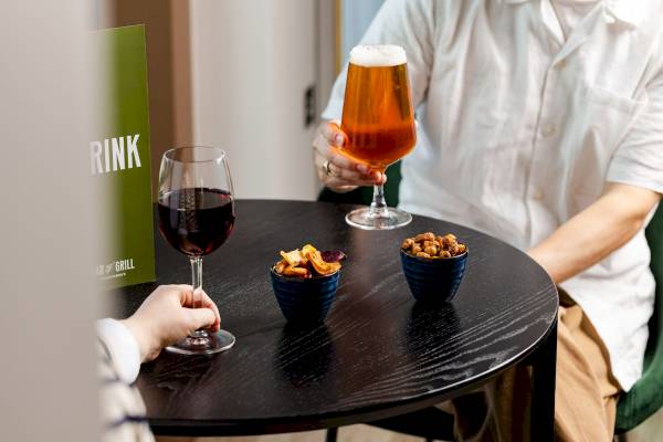 Ein Tisch mit zwei Getraenkeglaesern und Snacks in einer Bar.