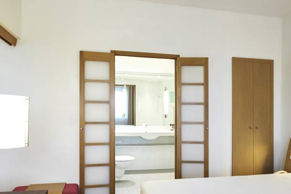 Innenansicht eines Zimmers im Novotel London West Hotel mit Bett, Schrank und Badezimmer