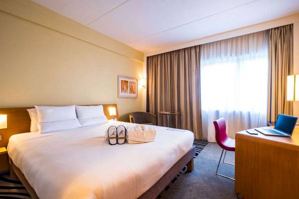Hotelzimmer im Novotel London West mit Bett, Schreibtisch und Laptop.