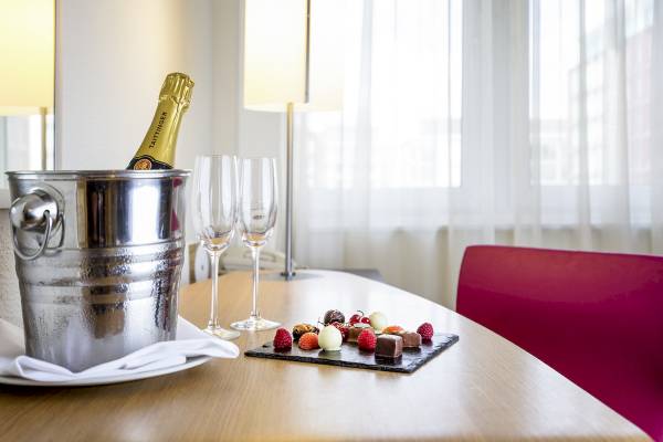 Ein Tisch mit einem Silbereimer, Champagner und einer Auswahl an Süßigkeiten.