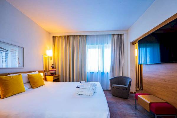 Novotel London West Hotelzimmer mit Bett, Fenster und Deko.