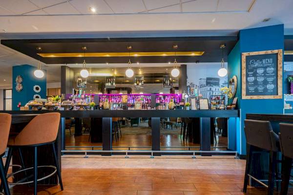 Innenansicht der Bar im Novotel London West Hotel mit Theke, Stühlen und Dekor.