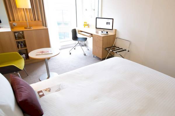 Hotelzimmer im DoubleTree by Hilton Tower of London mit Schreibtisch, Stuhl und Bett.