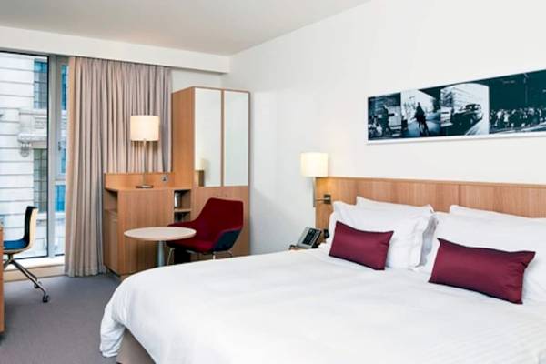 Doppelzimmer im DoubleTree by Hilton Tower of London mit Bett, Schreibtisch und Fenstern.