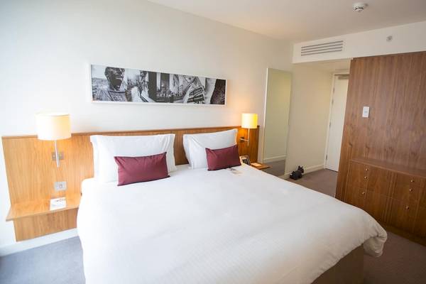 Doppelzimmer im DoubleTree by Hilton Tower of London mit weißem Bett und roten Kissen.