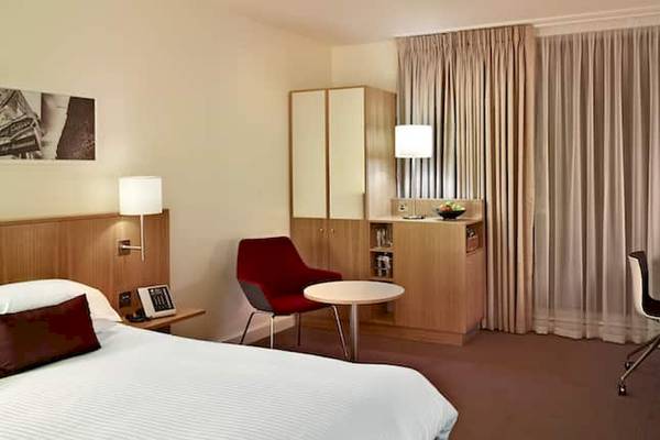 Doppelzimmer im DoubleTree by Hilton Tower of London mit Bett, Schreibtisch und Sessel.