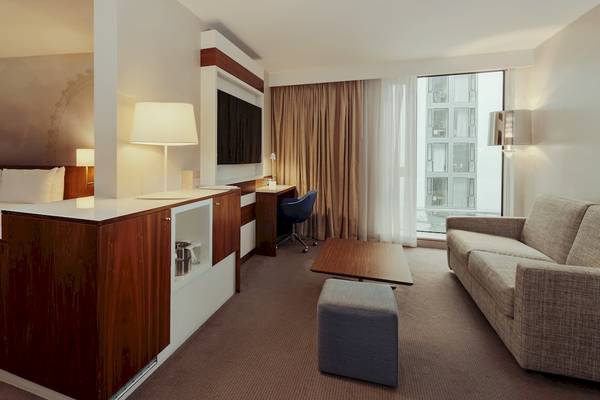 Innenansicht der Suite im DoubleTree by Hilton Tower of London mit Bett, Schreibtisch und Sofa.