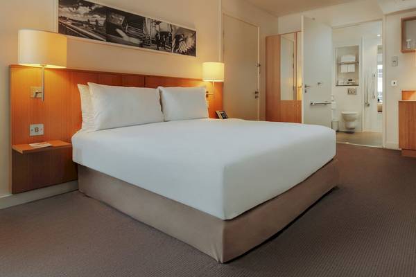Doppelzimmer im DoubleTree by Hilton Tower of London mit Bett, Lampen und Badezimmer.