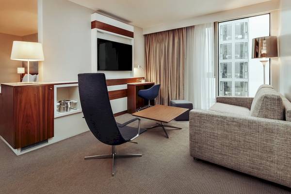 Innenansicht der Suite im DoubleTree by Hilton Tower of London mit Schreibtisch, Fernseher und Sitzbereich.