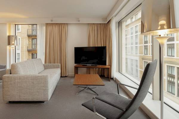 Doppelzimmer mit Wohnbereich und Fernseher in einem Hotel.