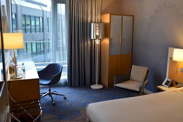 Hotelzimmer im DoubleTree by Hilton Tower of London mit Bett, Schreibtisch, Stühlen und Lampen.