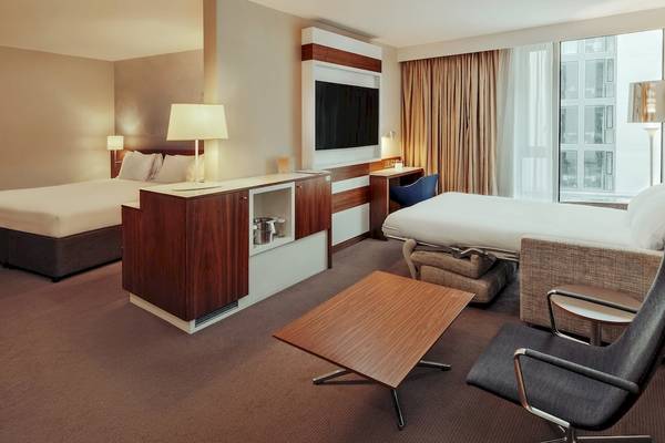 Doppelzimmer im DoubleTree by Hilton Tower of London Hotel mit zwei Betten, Schreibtisch, Fernseher, Sofa und Tisch.