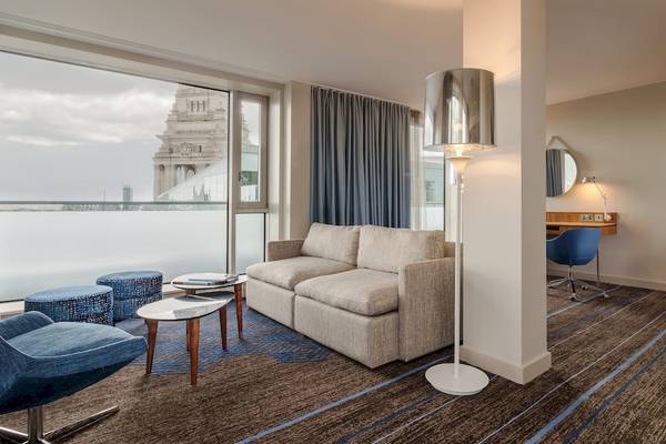 Innenbereich des DoubleTree by Hilton Tower of London Hotel mit Wohnzimmer und Schreibtisch.