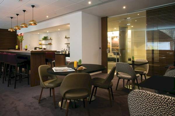 Innenbereich des DoubleTree by Hilton Tower of London mit Sitzbereichen und einer Bar.