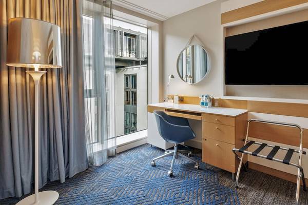 Hotelzimmer im DoubleTree by Hilton Tower of London mit Schreibtisch, Stuhl und Fernseher.