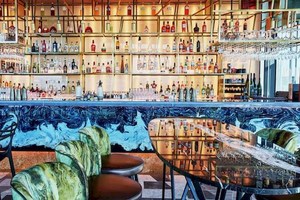 Bar im DoubleTree by Hilton Tower of London mit blauem Wanddesign und vielen Getränken