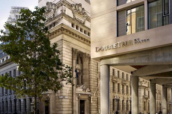 Haupteingang des DoubleTree by Hilton Tower of London mit Säulen und Bäumen davor.