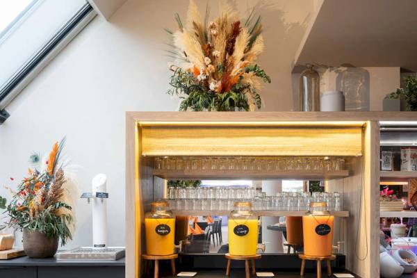 Frühstücksbuffet im Novotel Paris Centre Bercy mit bunten Getränkespendern und Dekoration.