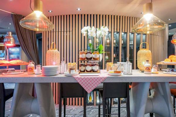 Frühstückstisch im Novotel Paris Centre Bercy mit Obst, Marmeladen und Getränken.