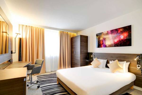 Ein modernes Hotelzimmer im Novotel Paris Centre Bercy mit einem Bett, Dekor und Möbeln.
