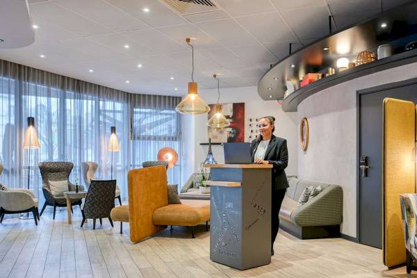 Frau am Empfangsschalter im Novotel Paris Centre Bercy mit Laptop
