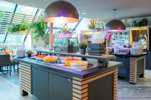 Buffet-Tisch im Novotel Paris Centre Bercy mit verschiedenen Gerichten und Pflanzen.