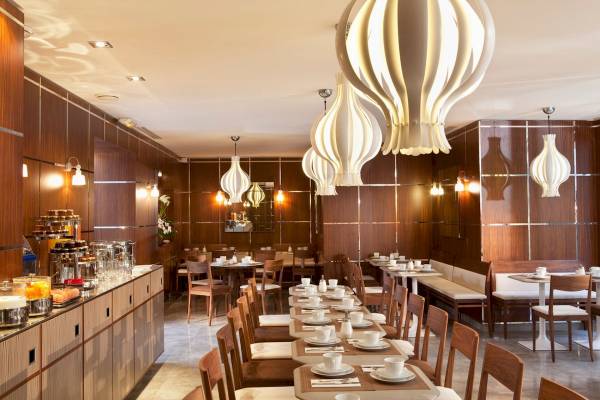 Innenansicht des Les Jardins d' Eiffel Restaurants mit gedämpften Lampen und Holzmöbeln.