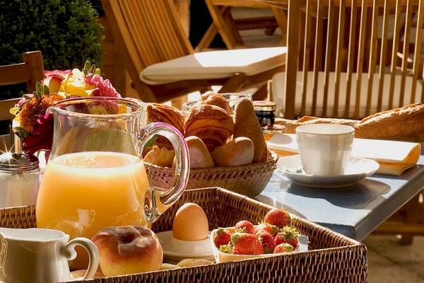 Frühstücksbuffet im Hotel Les Jardins d'Eiffel mit Brot, Croissants, Früchten und Getränken.