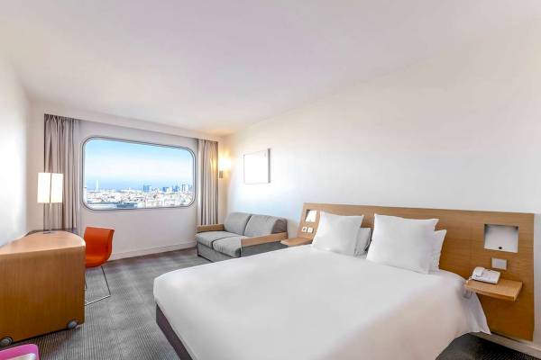Hotelzimmer im Novotel Paris Tour Eiffel mit großem Fenster und Blick auf die Stadt.