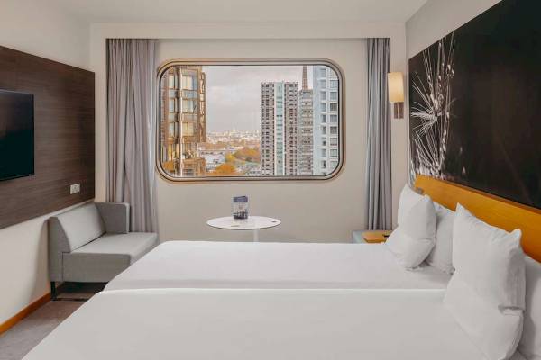Hotelzimmer im Novotel Paris Tour Eiffel mit Aussicht auf die Stadt und die Eiffelturm.