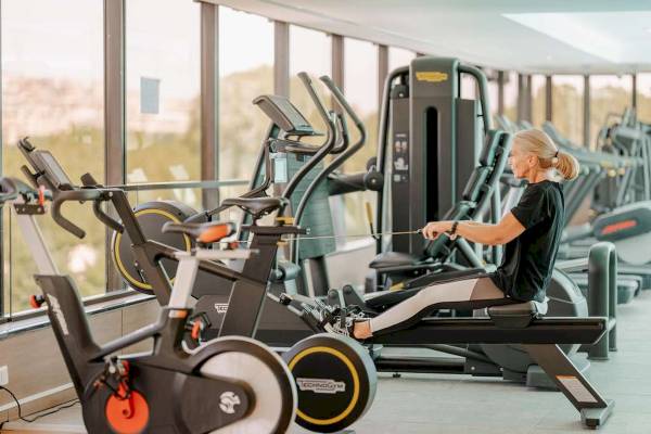 Eine Frau trainiert auf einem Rudergerät im Fitnessraum des Novotel Paris Tour Eiffel.