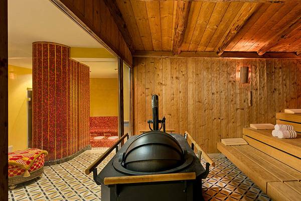 Saunabereich im Titanic Mardan Palace mit Holzwänden, Bankreihen und zentralem Ofen.