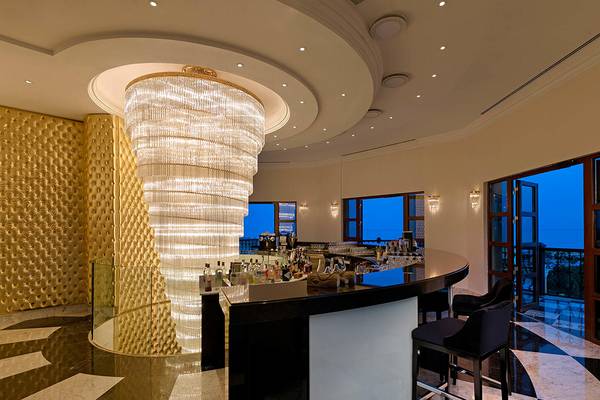 Innenansicht der Bar im Titanic Mardan Palace mit großem Kristallleuchter und Blick auf die Stadt.
