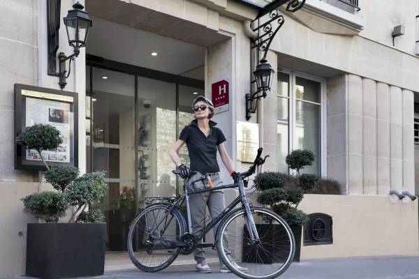 Frau mit Fahrrad vor dem Hotel Victor Hugo Paris Kléber