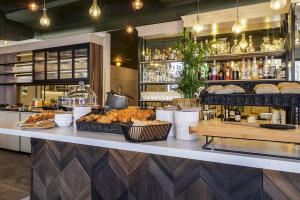 Frühstücksbereich im Mercure Paris Bercy Bibliothèque mit Croissants, Brot und Getränken.
