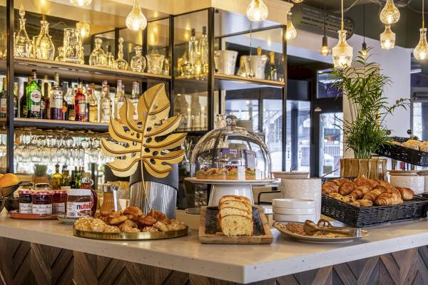 Frühstücksbuffet im Mercure Paris Bercy Bibliothèque mit verschiedenen Gebäck, Brot und Früchten.