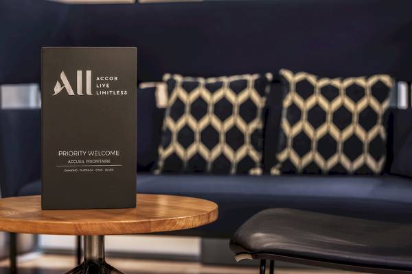Buch mit dem Titel Priority Welcome von Accor Live Limitless vor einem blauen Sofa