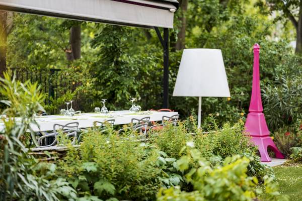 Außenbereich des Mercure Paris Centre Tour Eiffel mit Tisch, Stühlen und Gartendeko