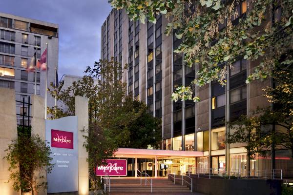 Außenansicht des Mercure Paris Centre Tour Eiffel Hotels bei Nacht mit hellen Fenstern und Bäumen